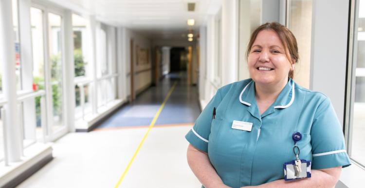 A nurse standing in a hallway in a hospital A nurse standing in a hallway in a hospital