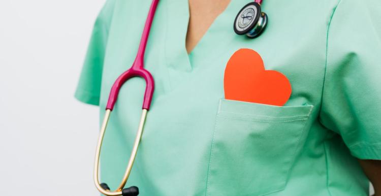 A healthcare professional with a stethoscope and red heart symbol 