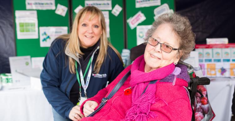 Healthwatch Volunteer at a community event speaking to a woman in a wheelchair Healthwatch Volunteer at a community event speaking to a woman in a wheelchair