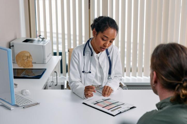 A doctor consulting with a patient in an office, discussing a medical chart. 