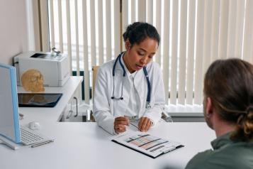 A doctor consulting with a patient in an office, discussing a medical chart. 