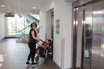 Woman pushing a buggy into a lift