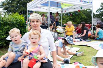 Woman sitting in the park with her two children on her lap