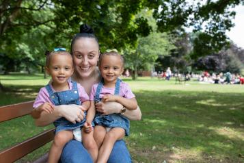 Woman with twin baby girls smiling at the camera