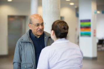 Man speaking to someone working in a health centre