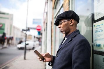 man holding a phone outside a building