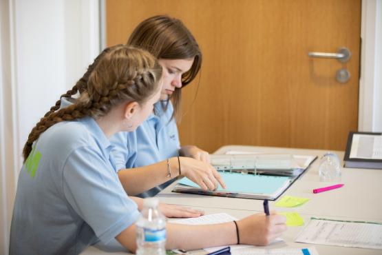 Two girls working together at a table