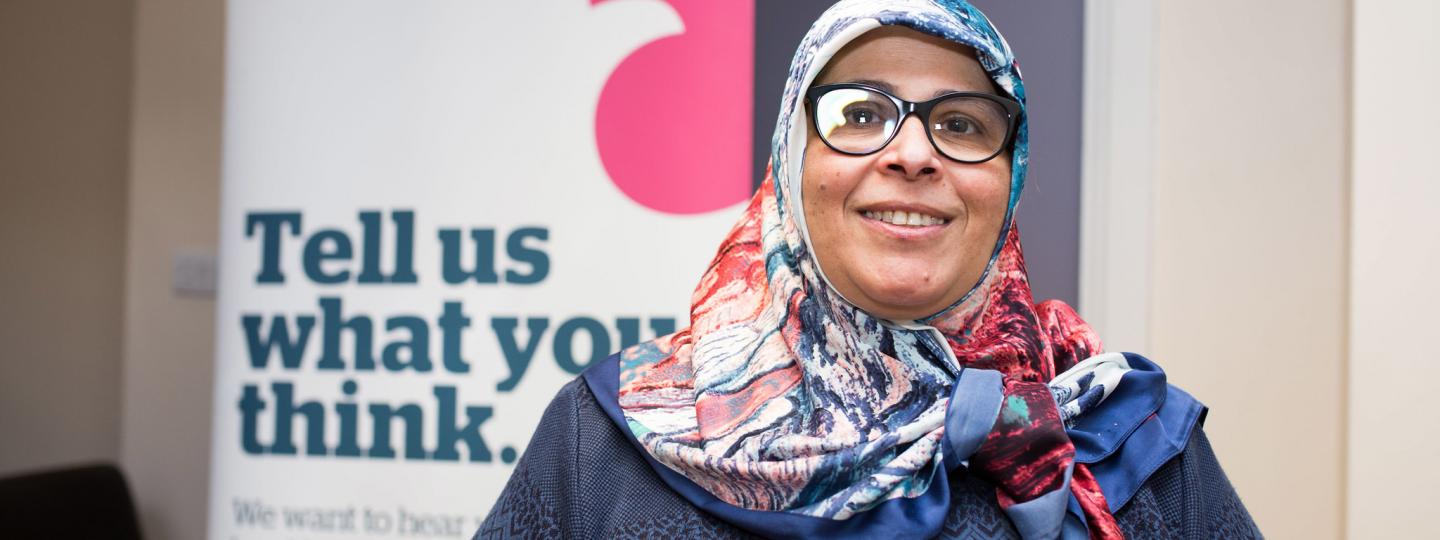 Volunteer standing in front of a Healthwatch banner