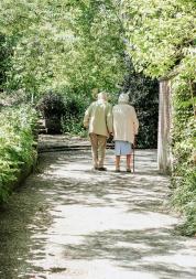 two elderly people walking in a park